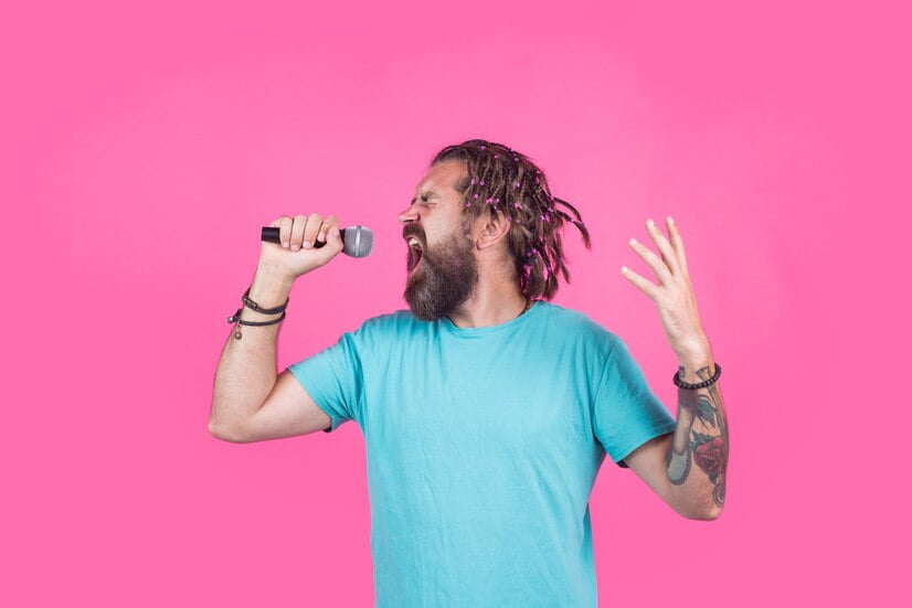 משפחה נהנית ממסיבת קריוקי: שני ילדים ומבוגרת שרים ביחד מול בידורית קריוקי עם מיקרופונים ביד, כולם מחייכים וצוחקים, תאורה צבעונית מוסיפה לאווירה השמחה ברקע סלון ביתי עם בלונים וקישוטים למסיבה.